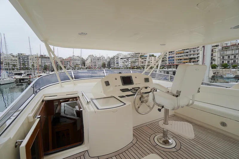 Slide: The Image of Flybridge of 2009 Marlow 61E yacht with helm station, overlooking marina and cityscape. - 16
