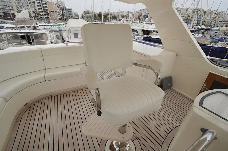 Slide: The Image of Luxury yacht Marlow 61E, 2009 model, featuring elegant seating and teak deck in marina setting. - 19