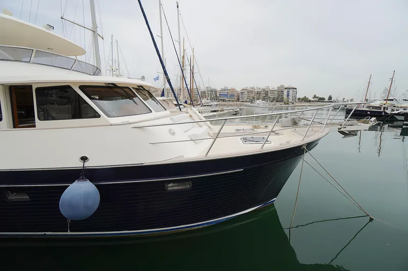 Slide: The Image of 2009 Marlow 61E yacht docked in a marina, surrounded by other boats. - 2