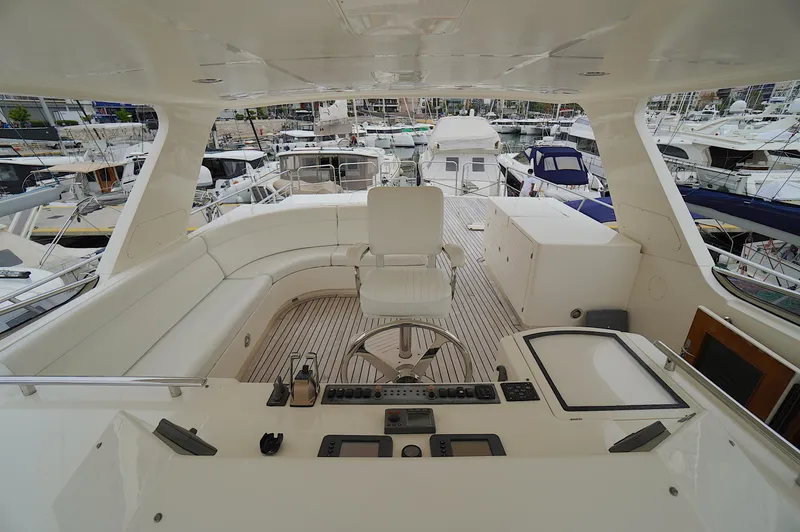 Slide: The Image of Luxurious 2009 Marlow 61E yacht deck with helm, seating, and marina view. - 20