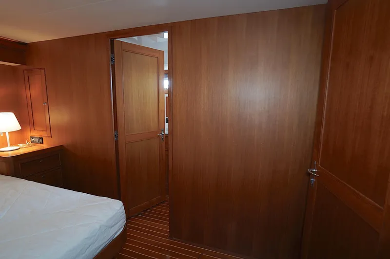 Slide: The Image of Wood-paneled cabin interior of 2009 Marlow 61E yacht with bed and lamp. - 22