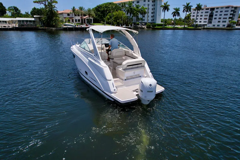 Slide: The Image of 2021 Regal 26 XO boat cruising on a sunny waterway with scenic background. - 13