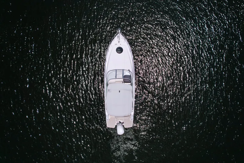 Slide: The Image of Aerial view of 2021 Regal 26 XO boat on shimmering water. - 16