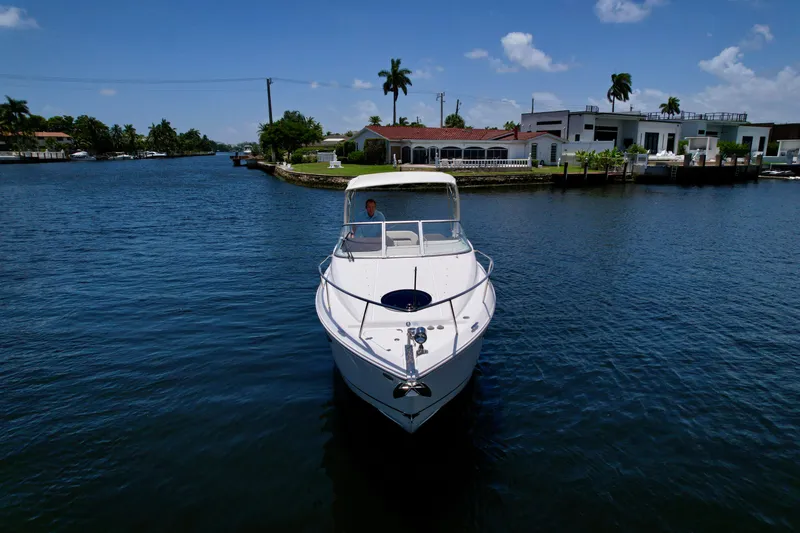 Slide: The Image of 2021 Regal 26 XO boat cruising on a sunny canal with waterfront homes. - 19