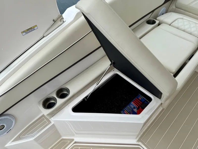 Slide: The Image of 2021 Regal 26 XO boat interior with open storage compartment and cup holders. - 29