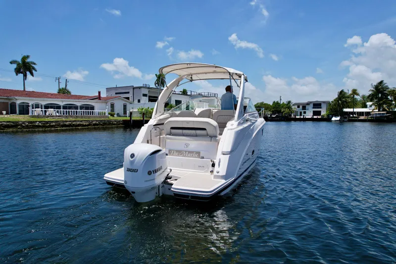 Slide: The Image of 2021 Regal 26 XO boat cruising on a sunny day in a residential canal. - 3