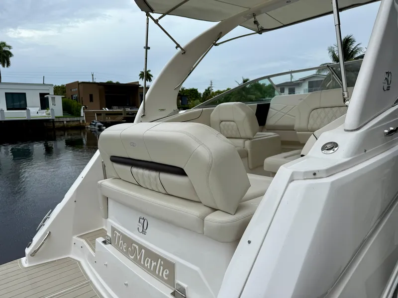 Slide: The Image of 2021 Regal 26 XO boat with luxurious seating, docked near waterfront homes. - 35