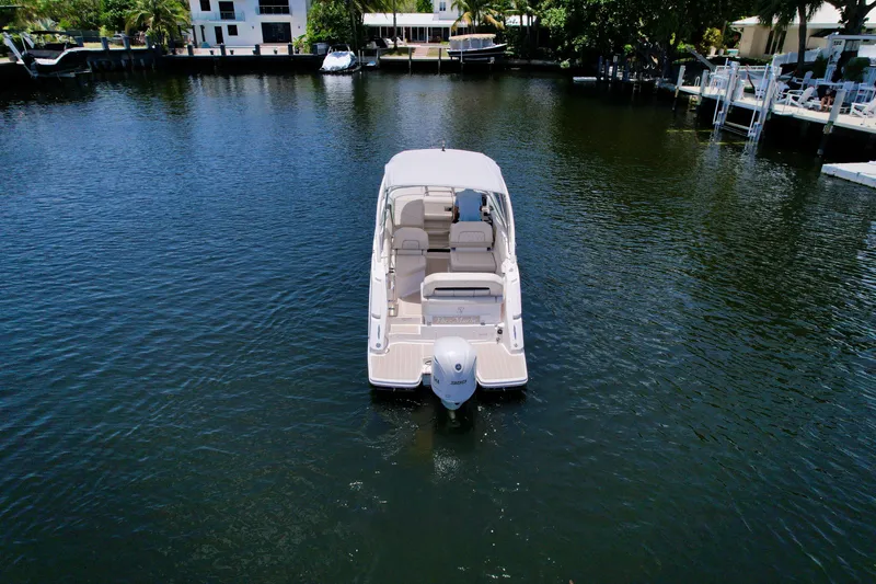 Slide: The Image of 2021 Regal 26 XO boat on calm water, surrounded by docks and greenery. - 4