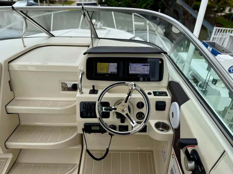 Slide: The Image of 2021 Regal 26 XO boat cockpit with steering wheel and navigation screens. - 43