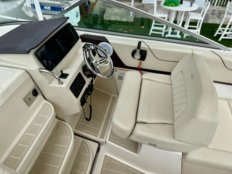 Slide: The Image of 2021 Regal 26 XO boat interior with steering wheel and seating area. - 45