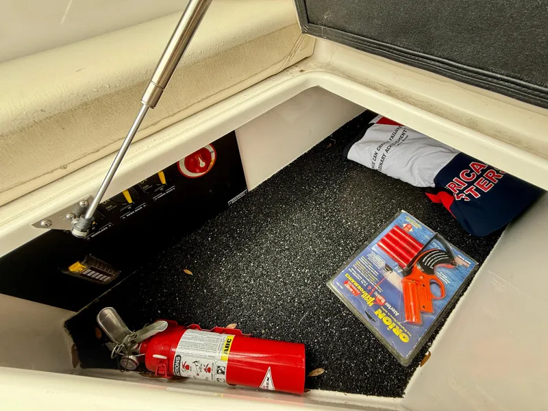 Slide: The Image of Storage compartment of 2021 Regal 26 XO boat with fire extinguisher and safety gear. - 48