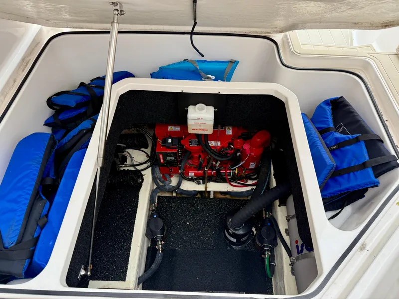 Slide: The Image of 2021 Regal 26 XO engine compartment with safety equipment and life jackets. - 49