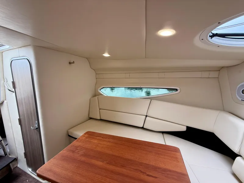 Slide: The Image of Interior of 2021 Regal 26 XO boat with cozy seating and wooden table. - 53