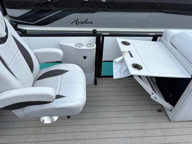 Slide: The Image of 2024 Bentley Pontoons Legacy QSB interior with swivel chair and foldable table. - 11