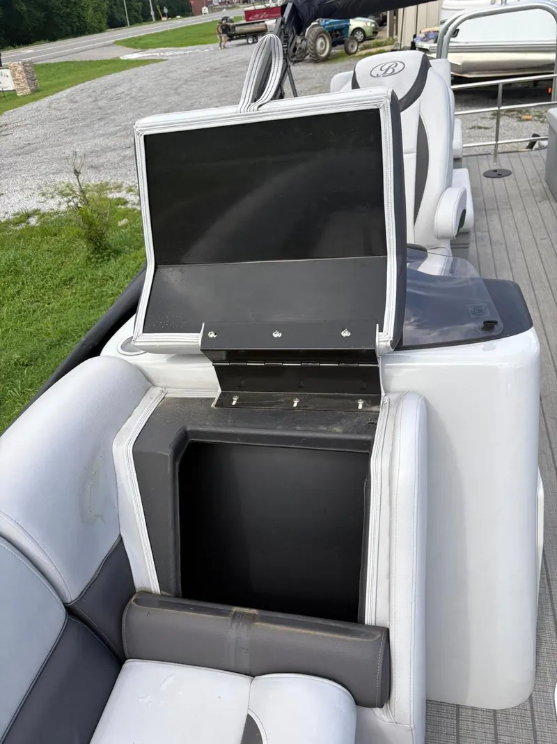 Slide: The Image of 2024 Bentley Pontoons Legacy QSB interior storage compartment with open lid on a boat deck. - 12