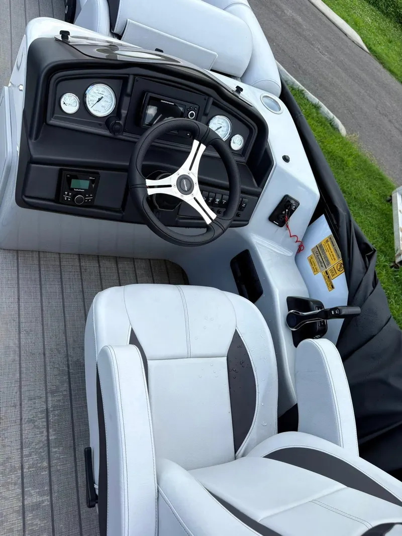 Slide: The Image of 2024 Bentley Pontoons Legacy QSB interior with steering wheel and dashboard controls. - 7