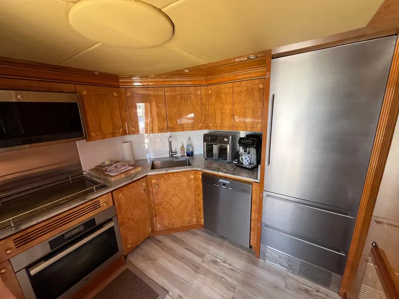 Slide: The Image of Luxurious kitchen in a 2001 Astondoa 95GLX yacht with modern appliances and wood cabinetry. - 47
