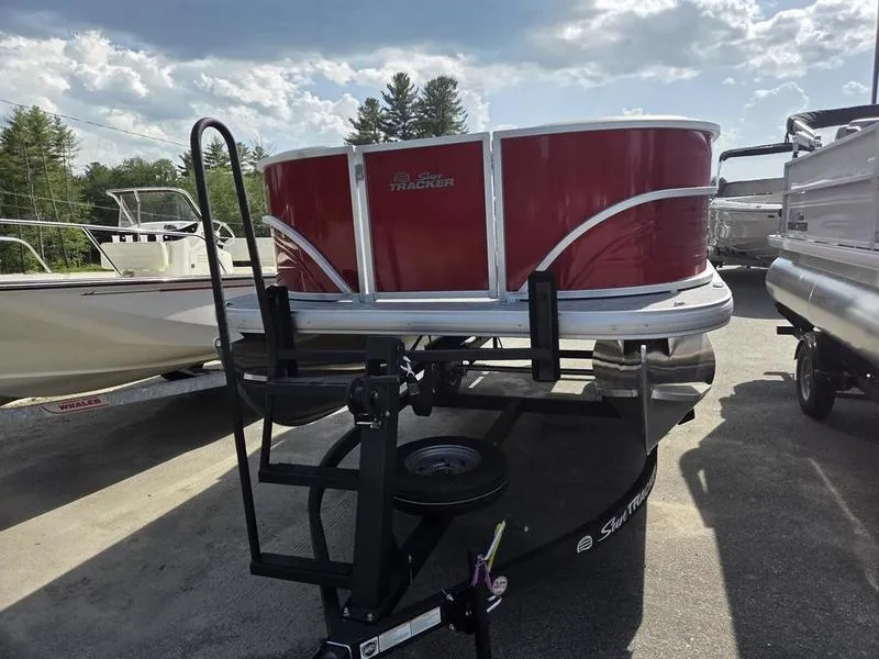 Slide: The Image of 2026 Sun Tracker PB 16 DLX pontoon boat on trailer, red exterior, parked outdoors. - 4