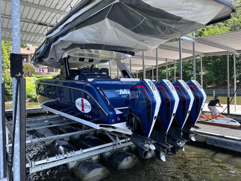 Slide: The Image of 2024 Cigarette 42 Auroris boat with four powerful outboard engines docked in a marina. - 2