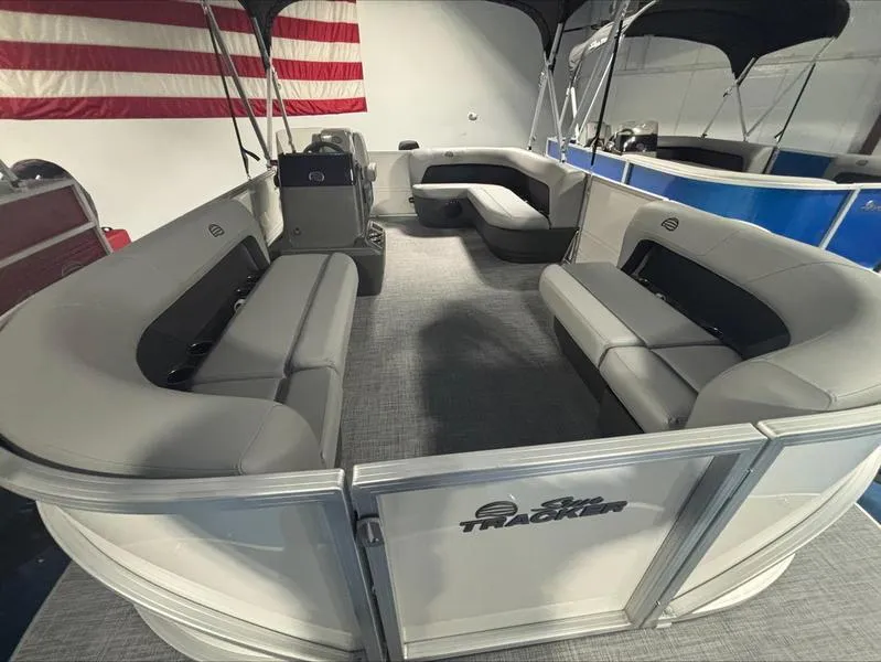 Slide: The Image of 2026 Sun Tracker PB 16 DLX pontoon boat interior with gray seating and American flag backdrop. - 4
