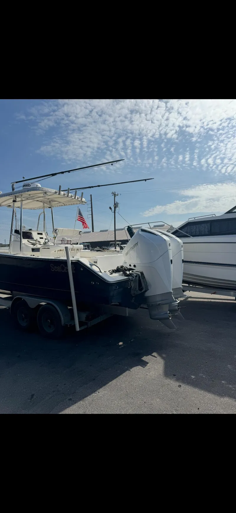 Slide: The Image of 2007 SeaCraft 25 boat on trailer under clear sky, featuring dual outboard motors. - 4