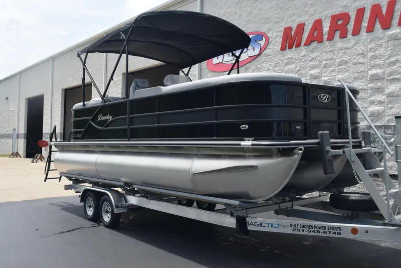 Slide: The Image of 2026 Bentley Pontoons Legacy 223 Navigator on trailer outside marine shop. - 2