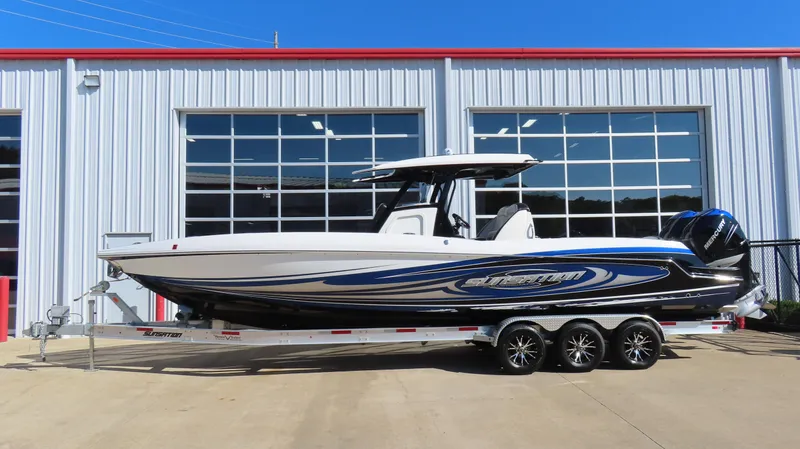 The Image of 2019 Sunsation 32 CCX boat on trailer, parked outside a garage. - 1