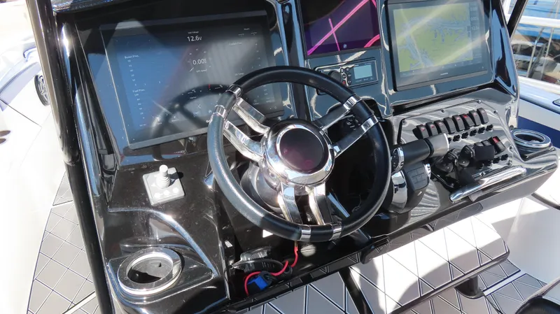 Slide: The Image of 2019 Sunsation 32 CCX boat dashboard with steering wheel and digital displays. - 12