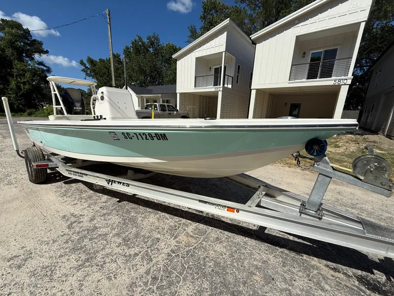 Slide: The Image of 2015 Hewes Redfisher 18 boat on trailer, parked in front of modern houses. - 3