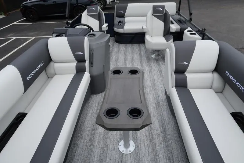 Slide: The Image of 2026 Bennington S Swingback 22 SSB interior with gray and white seating, cupholders, and table. - 10