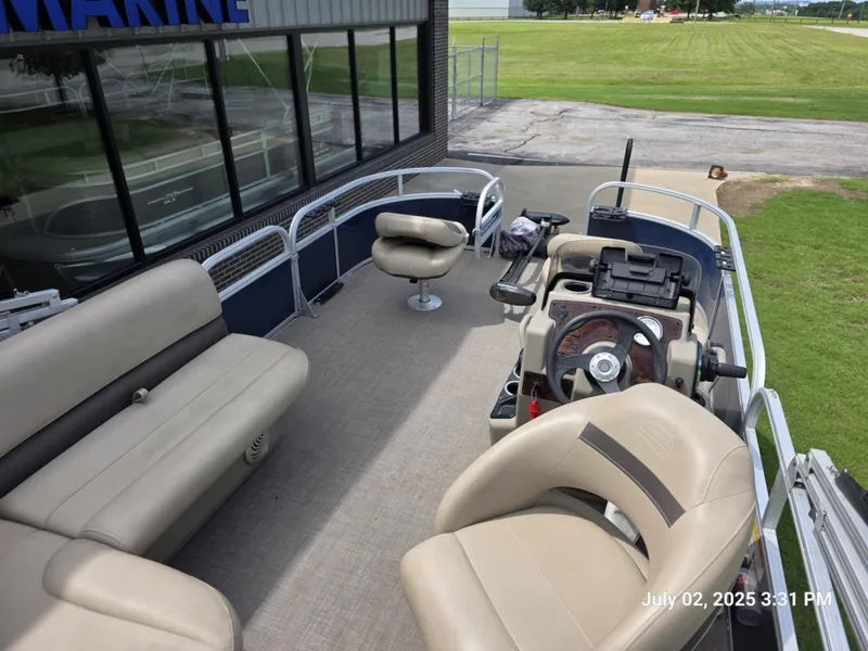 Slide: The Image of 2021 Sun Tracker Bass Buggy 16 XL pontoon boat interior with seating and steering console. - 2