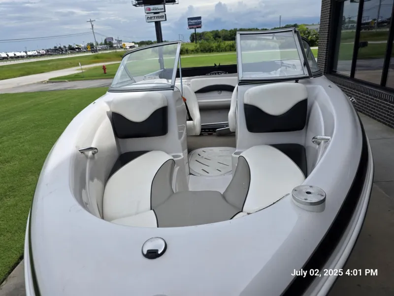 Slide: The Image of 2006 Tahoe Q6 SF boat with open seating, parked outdoors on a grassy area. - 8
