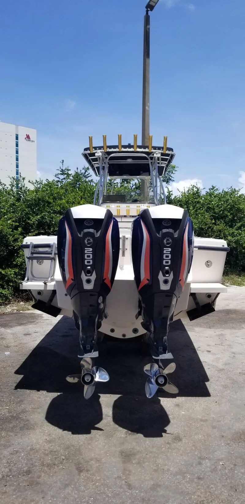 Slide: The Image of 1993 Intrepid 26 Walkaround boat with dual outboard engines, parked outdoors. - 10