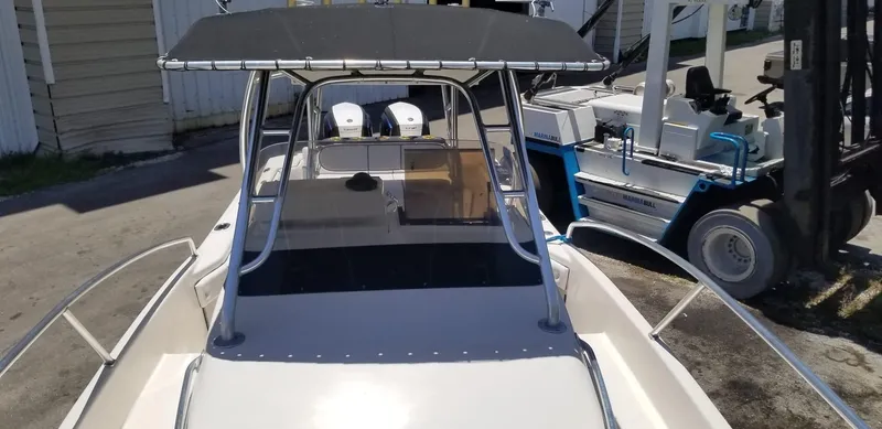 Slide: The Image of 1993 Intrepid 26 Walkaround boat with canopy, docked near a forklift. - 14