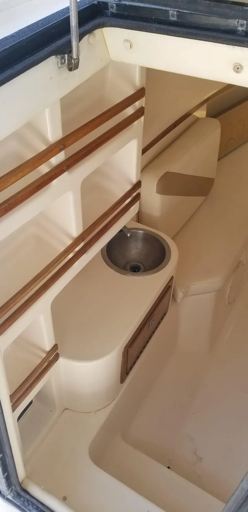 Slide: The Image of 1993 Intrepid 26 Walkaround cabin interior with sink and storage. - 15