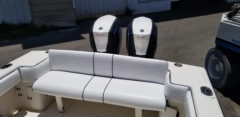 Slide: The Image of 1993 Intrepid 26 Walkaround boat with dual Evinrude engines and white seating. - 17