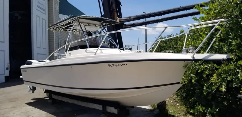 Slide: The Image of 1993 Intrepid 26 Walkaround boat on dry dock, white hull, metal railings, and canopy. - 4