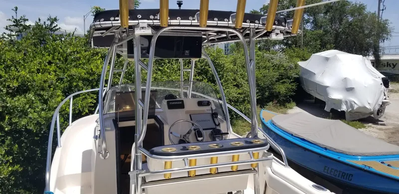 Slide: The Image of 1993 Intrepid 26 Walkaround boat with T-top and fishing rod holders, parked outdoors. - 8
