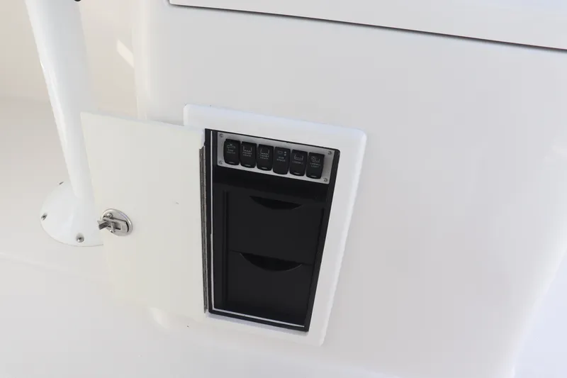 Slide: The Image of Control panel on a 2021 Albemarle 31 DC boat, featuring switches and storage compartments. - 23