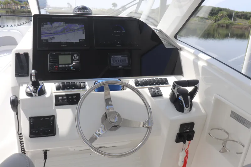 Slide: The Image of 2021 Albemarle 31 DC boat dashboard with steering wheel, navigation screens, and controls. - 25