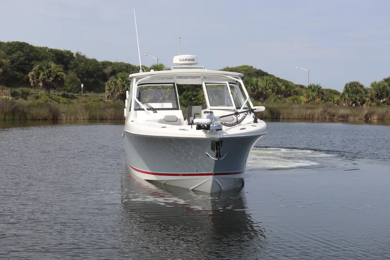 Slide: The Image of 2021 Albemarle 31 DC boat on calm water, surrounded by lush greenery. - 3
