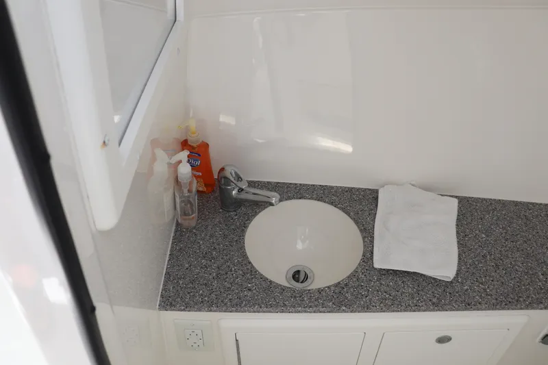 Slide: The Image of Bathroom sink area in 2021 Albemarle 31 DC boat with toiletries and towel. - 31