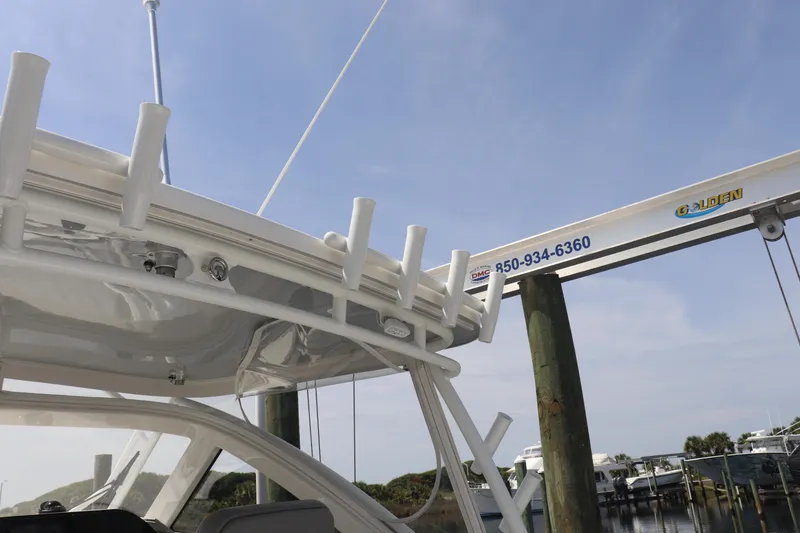 Slide: The Image of 2021 Albemarle 31 DC boat docked, featuring rod holders and marina crane in the background. - 33