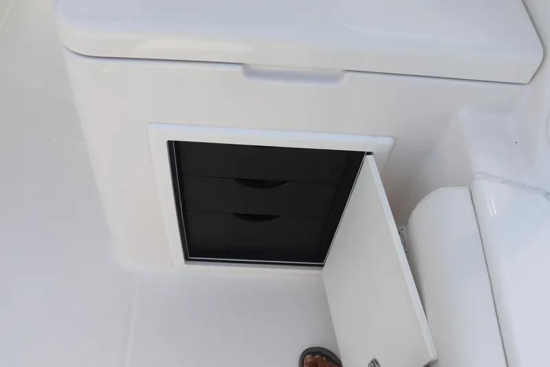 Slide: The Image of 2021 Albemarle 31 DC boat storage compartment with open door and visible drawers. - 44
