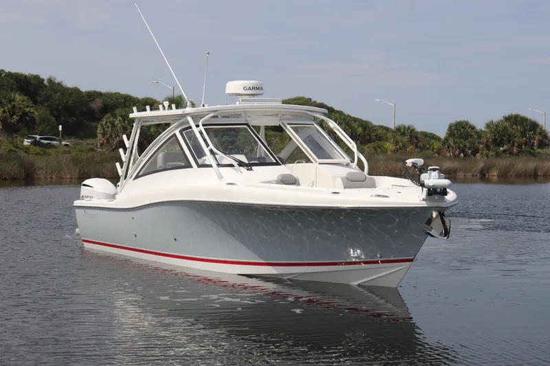 Slide: The Image of 2021 Albemarle 31 DC boat on calm water with lush greenery background. - 9