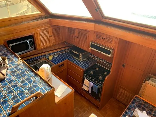 Slide: The Image of Cozy kitchen in 1984 CHB 48 boat with blue tiled countertops and wooden cabinetry. - 17