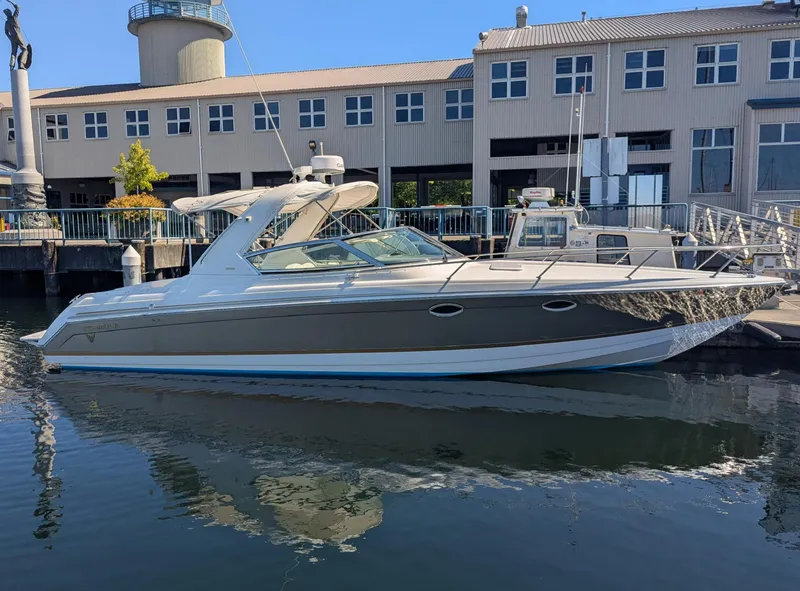 Slide: The Image of 2003 Formula 330 SS boat docked at marina, with modern building in background. - 0