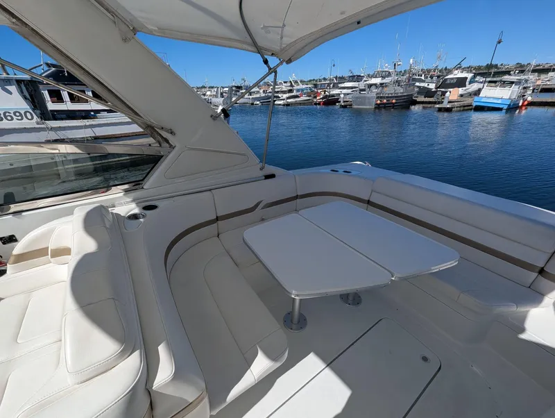 Slide: The Image of 2003 Formula 330 SS boat interior with white seating and table, docked at marina. - 6