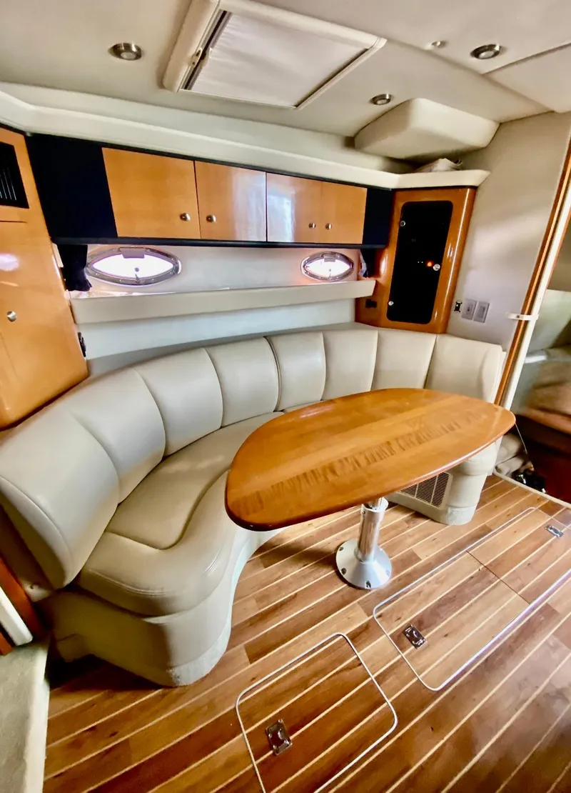 Slide: The Image of 2008 Chaparral 350 Signature yacht interior with curved seating and wooden table. - 10