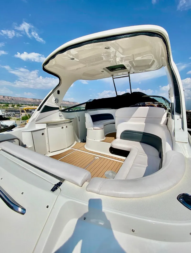 Slide: The Image of 2008 Chaparral 350 Signature boat interior with seating and cabinetry under a clear sky. - 2